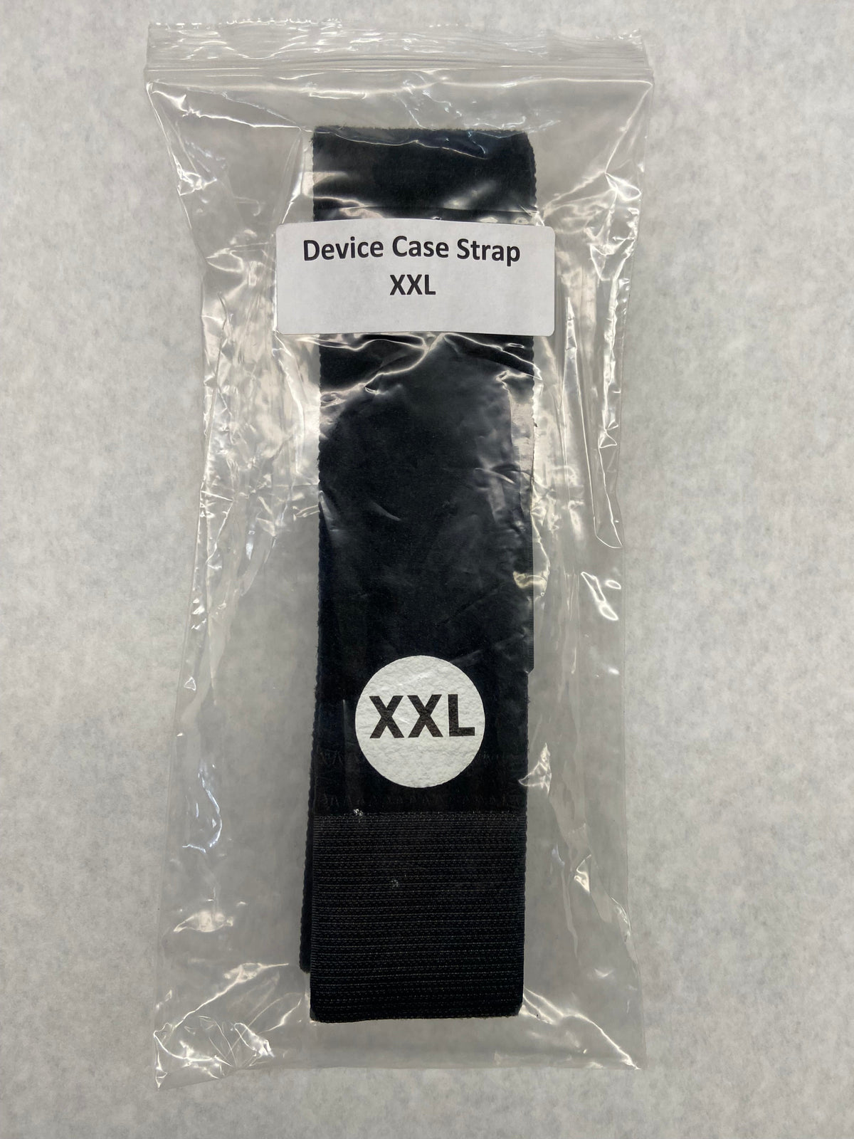 Black device case strap XXL in clear packaging with label on a gray background